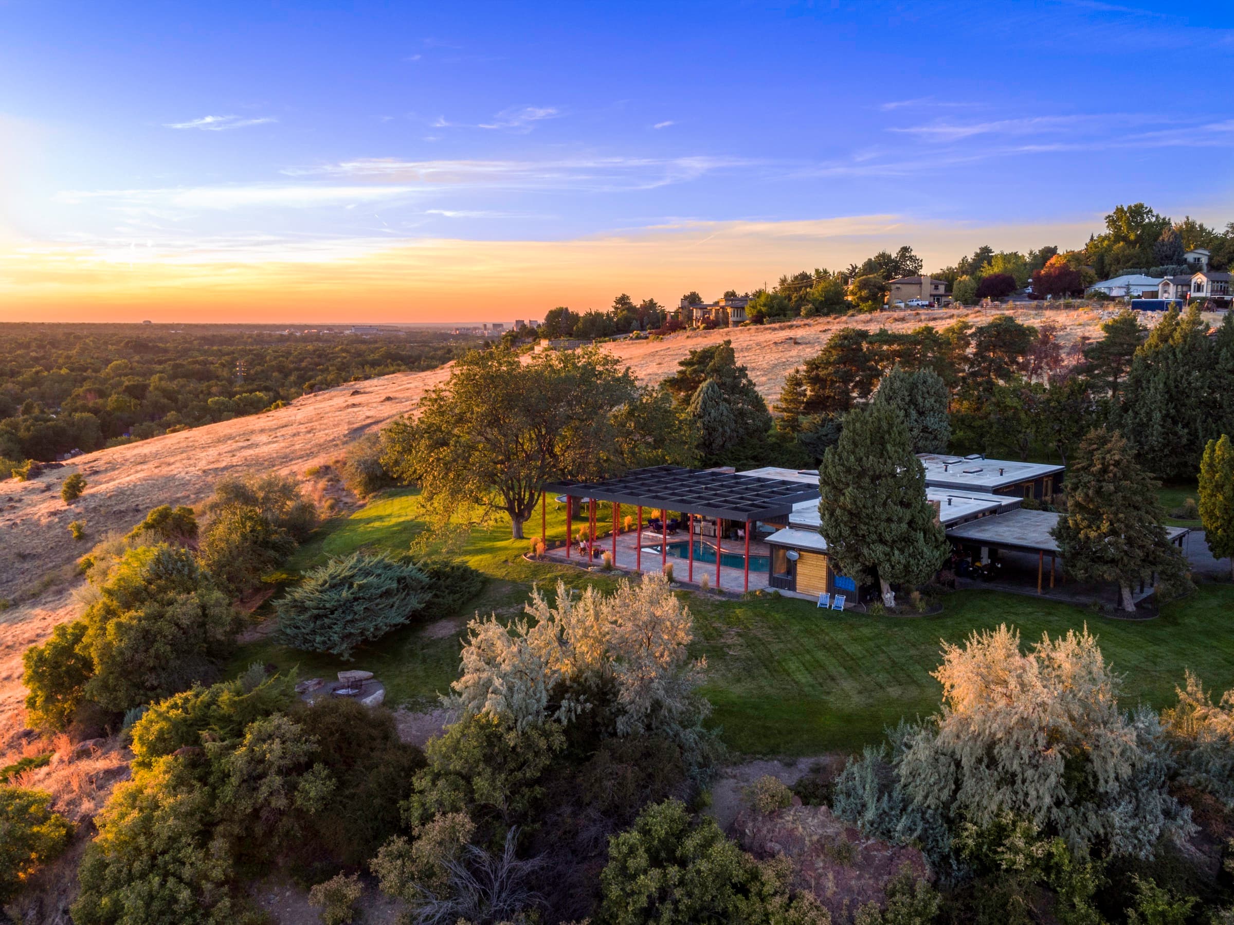 Mid-century modern home on the bluff above Boise at sunset, the valley beyond